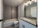Well-lit bathroom featuring a shower-tub combo, granite countertop, and modern vanity at 6178 Sw 207Th Ct, Dunnellon, FL 34431