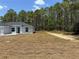 Close up of home focusing on right side, yard and part of treeline to rear at 6178 Sw 207Th Ct, Dunnellon, FL 34431