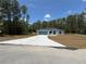 A cozy home featuring a long, wide driveway and plenty of green space surrounding the house at 6178 Sw 207Th Ct, Dunnellon, FL 34431
