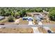 Aerial view of a single-Gathering home with a manicured lawn on a quiet street, near a green, wooded area at 6570 Sw 129Th Loop, Ocala, FL 34473