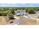 Aerial view of a single-Gathering home with a manicured lawn on a quiet street, near a green, wooded area at 6570 Sw 129Th Loop, Ocala, FL 34473