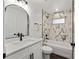 Modern bathroom featuring marble-style tile, an arched mirror, and sleek black fixtures at 6570 Sw 129Th Loop, Ocala, FL 34473