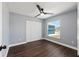 Light-filled bedroom with a contemporary ceiling fan, wood-look flooring, and a view of the outdoors at 6570 Sw 129Th Loop, Ocala, FL 34473