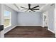 Spacious primary bedroom with tray ceiling, ceiling fan, and ensuite bathroom with round mirrors at 6570 Sw 129Th Loop, Ocala, FL 34473