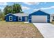 Charming blue single-story home with a two-car garage and well-lit front entrance at 6570 Sw 129Th Loop, Ocala, FL 34473