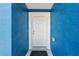 Clean white front door of a blue home, offering a welcoming entrance at 6570 Sw 129Th Loop, Ocala, FL 34473
