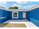 Inviting front entrance of a blue home, featuring a bright white door and window at 6570 Sw 129Th Loop, Ocala, FL 34473