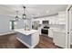 Bright open kitchen with white cabinets, stainless steel appliances, island and wood-look flooring at 6570 Sw 129Th Loop, Ocala, FL 34473
