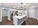 Open concept living room featuring hardwood floors, stainless steel appliances and a white island at 6570 Sw 129Th Loop, Ocala, FL 34473