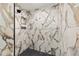 Modern walk-in shower with decorative tiles and black pebble flooring at 6570 Sw 129Th Loop, Ocala, FL 34473