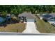 Aerial view of a well-maintained single-story home with a lush green lawn, two car garage, and spacious driveway at 6791 Se 100Th Pl, Belleview, FL 34420