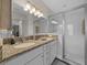 A bathroom features granite countertops, double sinks, and a large, tiled walk-in shower at 6791 Se 100Th Pl, Belleview, FL 34420