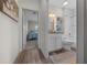 Hallway view into updated bathroom featuring new vanity, toilet, shower and decorative touches at 6791 Se 100Th Pl, Belleview, FL 34420