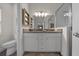 Bathroom shows granite countertops, double sinks, white cabinets, and tiled walk-in shower at 6791 Se 100Th Pl, Belleview, FL 34420