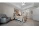 A bedroom featuring a queen bed, sitting chair, neutral colors, and an en-suite bathroom at 6791 Se 100Th Pl, Belleview, FL 34420
