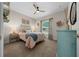 Comfortable bedroom with soft carpet, ceiling fan, and a large window that brings in plenty of natural light at 6791 Se 100Th Pl, Belleview, FL 34420
