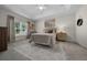 A bedroom has a tray ceiling, large window, neutral colors, and light carpet at 6791 Se 100Th Pl, Belleview, FL 34420