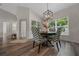 Dining room with a round table, four chairs, modern chandelier, and lots of natural light at 6791 Se 100Th Pl, Belleview, FL 34420