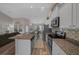 A kitchen features an island with a sink, stainless steel appliances, and wooden floor at 6791 Se 100Th Pl, Belleview, FL 34420