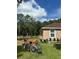 Charming home exterior with lush green lawn, pink bench, bicycle, and mature trees at 7488 Sw 204Th Ave, Dunnellon, FL 34431