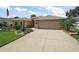 Beautiful home features a lush green lawn, vibrant flowerbeds, and an expansive driveway at 8545 Se 168Th Kittredge Loop, The Villages, FL 32162