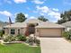 Well-maintained single-story home with lush green lawn, vibrant flowerbeds, and a spacious driveway at 8545 Se 168Th Kittredge Loop, The Villages, FL 32162