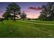 Scenic view of a golf course and a lake under a vibrant sunset sky at 8545 Se 168Th Kittredge Loop, The Villages, FL 32162