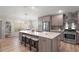 Stylish kitchen featuring an island with seating, stainless steel appliances, and a modern backsplash at 8545 Se 168Th Kittredge Loop, The Villages, FL 32162