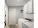 Laundry room with tile floors, a laundry sink, washer, dryer, and white storage cabinets at 8545 Se 168Th Kittredge Loop, The Villages, FL 32162