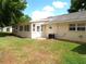 View of the backyard with lanai, green grass and an AC Unit at 8653 Sw 95Th Ln # F, Ocala, FL 34481