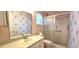 This bathroom features a shower with glass doors, updated vanity, and decorative floral wallpaper at 8653 Sw 95Th Ln # F, Ocala, FL 34481