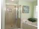 Bright bathroom featuring a glass-enclosed shower and a separate bathtub for relaxation and convenience at 9129 Sw 193Rd Cir, Dunnellon, FL 34432