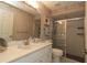 Well-lit bathroom featuring a vanity, mirror, and a tiled shower with glass doors at 9129 Sw 193Rd Cir, Dunnellon, FL 34432