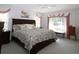 Bright bedroom with floral bedding, a ceiling fan, and lots of natural light from the large windows at 9129 Sw 193Rd Cir, Dunnellon, FL 34432