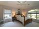 Comfortable bedroom with a wooden bed frame, soft carpet, and natural light at 9129 Sw 193Rd Cir, Dunnellon, FL 34432