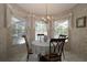 Cozy dining area with chandelier and sunlit view of the pool and backyard at 9129 Sw 193Rd Cir, Dunnellon, FL 34432