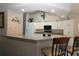 Bright kitchen with textured wallpaper, ample white cabinets, and an island with bar seating at 9129 Sw 193Rd Cir, Dunnellon, FL 34432