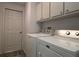 Functional laundry room with modern washer and dryer units and storage cabinets at 9129 Sw 193Rd Cir, Dunnellon, FL 34432