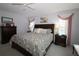 Inviting primary bedroom with a decorative bed, two windows, and dresser at 9129 Sw 193Rd Cir, Dunnellon, FL 34432