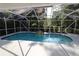 Screened-in pool surrounded by privacy landscaping and a unique rock feature for outdoor enjoyment at 9129 Sw 193Rd Cir, Dunnellon, FL 34432
