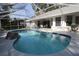 Enclosed swimming pool area offers leisure with an outdoor dining set and lush backyard privacy at 9129 Sw 193Rd Cir, Dunnellon, FL 34432