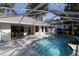 Screened-in pool with a rock feature, providing a private backyard oasis for swimming and relaxation at 9129 Sw 193Rd Cir, Dunnellon, FL 34432
