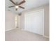 This is a bedroom with neutral paint, carpet flooring, a ceiling fan, and a closet with white doors at 9250 Sw 197Th Cir, Dunnellon, FL 34432