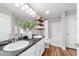 Bright bathroom with double sinks, granite countertop, decorative shelving, and a shower-tub combo at 9595 Sw 51St Cir, Ocala, FL 34476
