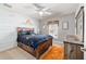 Charming bedroom with wood accent wall, ceiling fan, and cozy furnishings, bathed in natural light at 9595 Sw 51St Cir, Ocala, FL 34476