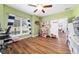 Spacious bedroom with hardwood floors, natural light, and ceiling fan at 9595 Sw 51St Cir, Ocala, FL 34476