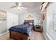 Comfortable bedroom featuring wood accent wall, ceiling fan, natural light, and ample closet space at 9595 Sw 51St Cir, Ocala, FL 34476