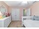 Bright bedroom showcasing a crib, ample closet space, and a stylish dresser, creating a serene atmosphere at 9595 Sw 51St Cir, Ocala, FL 34476