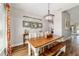 Dining room features a wood table, chandelier, bright window, and wood floors at 9595 Sw 51St Cir, Ocala, FL 34476
