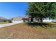 Attractive home exterior featuring a well-manicured lawn, mature landscaping, and a spacious driveway at 9595 Sw 51St Cir, Ocala, FL 34476